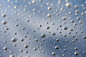Raindrops dance on a reflective surface under a cloudy sky during a tranquil moment of nature photo