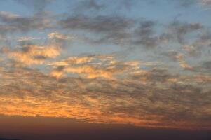 Majestic twilight sky painted with soft clouds and warm hues at dusk over the horizon photo