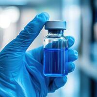 Researcher holds glass vial containing blue liquid in laboratory setting during scientific investigation photo