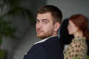 A close up shot of a charismatic director sitting at a business meeting, exuding confidence, focus, and leadership while engaging in a productive discussion. photo