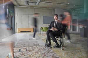 A businessman in a wheelchair navigating through a busy office, surrounded by his colleagues who are actively engaged in their work and collaboration photo