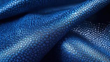 Close-up of blue textured fabric with light reflecting patterns and detailed surface photo