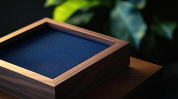 Wooden box with blue interior on wooden table and green leaves background photo