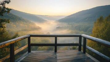 Scenic mountain valley overlook with misty morning fog and wooden platform photo