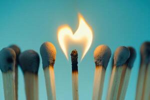Single matchstick igniting in a row of matches symbolizing inspiration and creativity photo