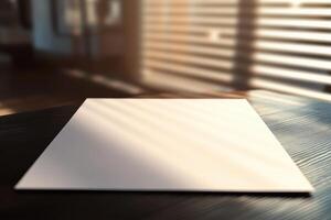 Empty white paper on wooden table in artistic sunlight through window blinds photo