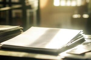 Sunlit stack of office papers on a wooden desk in a workspace setting photo
