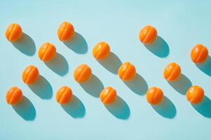 Fresh apricots with shadows arranged in pattern on light blue background photo