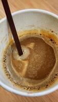 Coffee in a white cup on a wooden table, top view photo