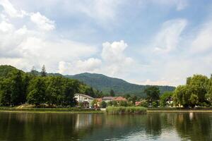 Scenic view of lake with forest and mountains in the distance photo