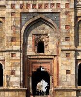 Ancient Indian building detail. Intricate Mughal-style stone architecture with arched windows, photo