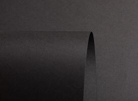 Jet black paper background with a matte, grainy texture and subtle gradient. Dark tones create a photo