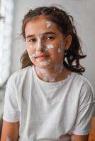 Portrait of a little girl with a red rash on her skin is looking out the window. She has chicken pox and measles on her face. photo