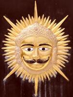 A golden sun with a mustache and a face photo