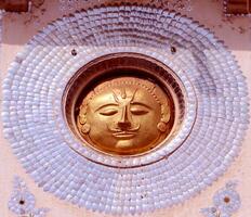 A gold face on a wall photo
