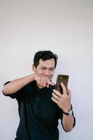 Man is smiling and pointing at smartphone screen, showing digital interaction or engagement. photo