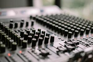 Close-up view of a sound mixer with numerous knobs and faders, ideal for music production so nice so photo