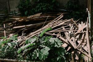 Pile of used wooden planks and beams, showing weathered textures and signs of previous usage, photo