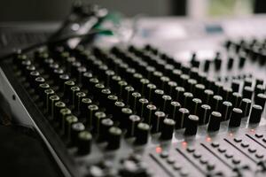 Close-up view of a sound mixer with numerous knobs and faders, ideal for music production so nice photo