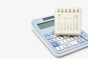 Desk calendar for NOVEMBER 2025 on calculator. Calendar concept with copy space. 2025 NOV calendar. calculator and forecast for finances in 2025. Money, Budget, investment and financial. photo