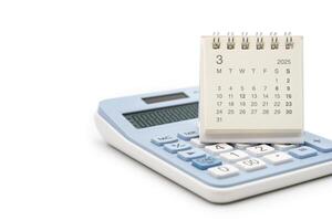 Simple desk calendar for MARCH 2025 on calculator. Calendar concept with copy space. 2025 MAR calendar. calculator and forecast for finances in 2025. Money, Budget, tax, investment and financial. photo
