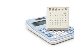 Simple desk calendar for FEBRUARY 2025 on calculator. Calendar concept with copy space. 2025 FEB calendar. calculator and forecast for finances in 2025. Money, Budget, tax, investment and financial. photo