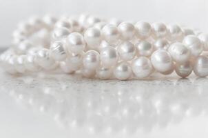 Nature white string of pearls on marble background in soft focus photo