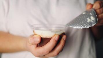 Fresh organic pudding for proper nutrition. Female hands slowly open the lid of yogurt, isolated on a white background video