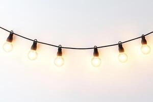 String of Warm White Edison Bulb Lights Hanging Against a Minimalist White Background photo