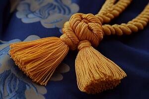 Elegant Close-Up of Ornate Golden Tassels on Luxurious Blue Fabric with Intricate Floral Patterns photo