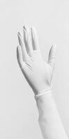 Close-Up of a Raised Hand in a White Latex Glove Against a Minimalist White Background photo