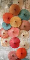 Colorful Array of Traditional Asian Paper Umbrellas Displayed Against a Textured Wall Background photo