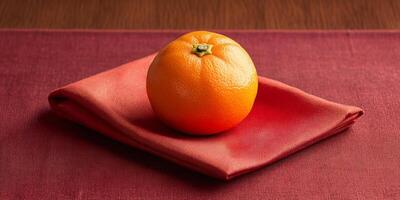 Fresh Orange on Red Napkin Against Wooden Table Background in Natural Light photo