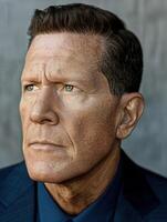 A man with a serious expression gazes thoughtfully into the distance photo
