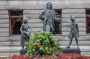 A statue of a man and two women in front of a building photo
