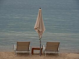Two chairs and an umbrella on the beach photo
