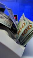 Female hand puts a stack of one hundred dollar bills into the modern money counting device. Side view. Close up. video