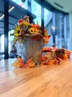 Festive autumn table arrangement with vibrant fall decorations and a miniature pumpkin. Warm tones and cozy ambiance evoke the spirit of the harvest season and Halloween celebrations photo
