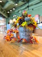 Festive autumn table arrangement with vibrant fall decorations and a miniature pumpkin. Warm tones and cozy ambiance evoke the spirit of the harvest season and Halloween celebrations photo