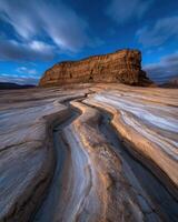 Striped sandstone formations under a twilight sky photo
