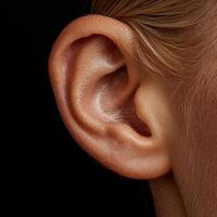 Close up of a womans ear, showing intricate details and skin texture photo