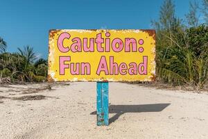 Caution. Fun Ahead A rustic beach sign points the way to summer adventures photo