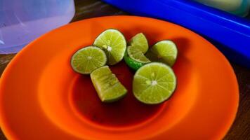 Fresh Lime Wedges on Orange Plate photo