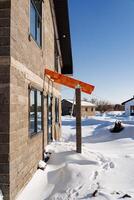 A house with a red awning on the side, against a snowy backdrop photo