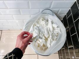 A person with a bag of tissue on hand while preparing a food recipe in the kitchen with buckwheat flour. photo