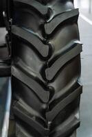 Close up of a tractor tire with grey synthetic rubber tread on the rim photo