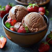 A bowl of rich chocolate ice cream topped with fresh strawberries photo
