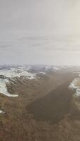 large snow patch left over on the volcanic rock field of a mountain in summer video