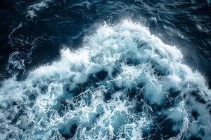Ocean wave creating white foam on blue water surface photo