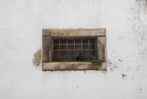 Old window of an ancient building on a white wall photo